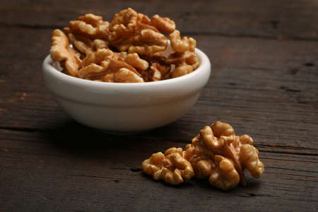 Group of delicious nuts in a bowl, over a wooden backgroundの写真素材