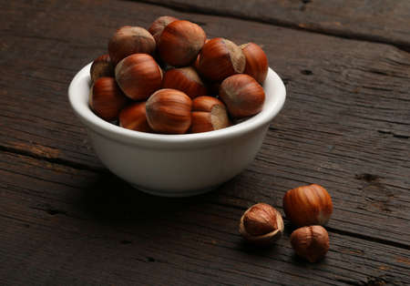Group of delicious nutshells in a bowl, over a wooden background