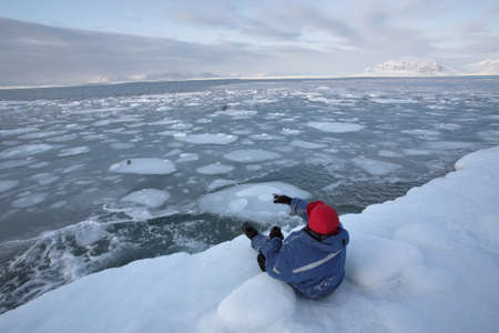 Arctic - Man throwing stones in the seaの写真素材