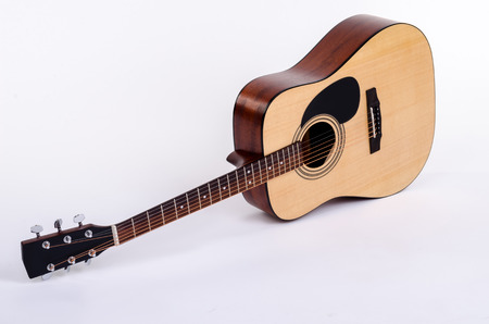 acoustic guitar lying flat on a white background isolatedの写真素材