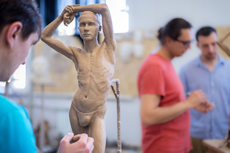 The sculptor sculpts a man's sculpture from natureの写真素材