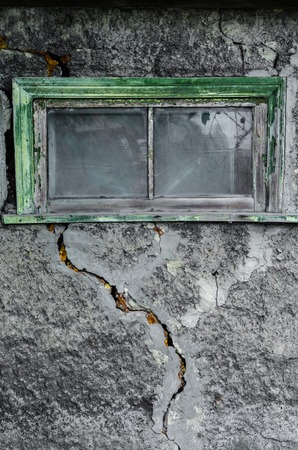 Texture of gray decorative plaster with a large crack and a window