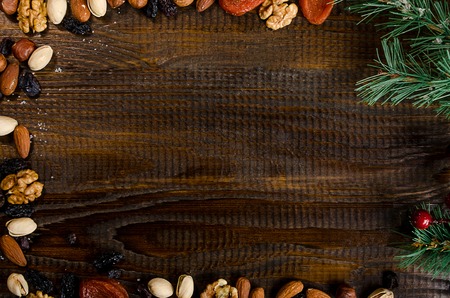 nuts, dried fruits, pistachios and homemade cookies scattered from the bag on the table, New Year attributes, with a place for writingの写真素材