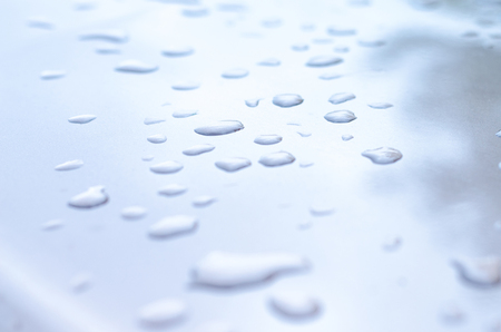 texture of a drop of water on a white glossy surfaceの写真素材