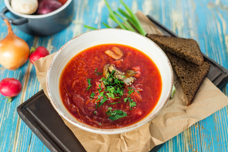 red soup with rolls on white tableの写真素材