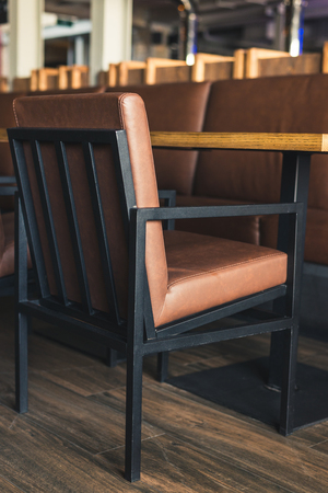 Brown soft chair in the restaurant, stands near the tableの写真素材