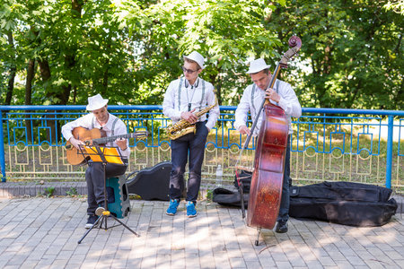 KIEV, UKRAINE - June 04, 2017. Street musicians: guitarist, saxophonist and bass player, play on the streetのeditorial素材