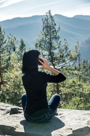 girl with dark hair on a background of mountainsの写真素材