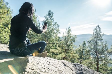 girl with dark hair on a background of mountainsの写真素材