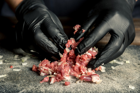 female hands mix onion and meat on a wooden board. Horizontal frameの写真素材