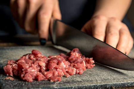 chef hands cut red meat on a board. Horizontal frameの写真素材