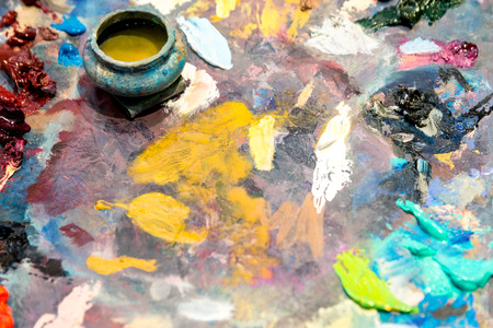 Paints of different colors on a multi-colored palette of mixed oil paints. Horizontal frameの写真素材