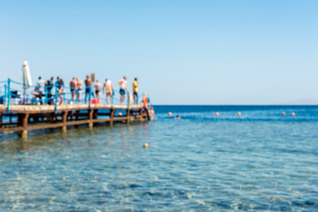 travel and vacation, sea, pier with people in defocus. Horizontal frameの写真素材
