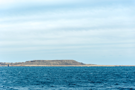 Seascape, view of the blue sea with high bald mountains in the background. Horizontal frameの写真素材