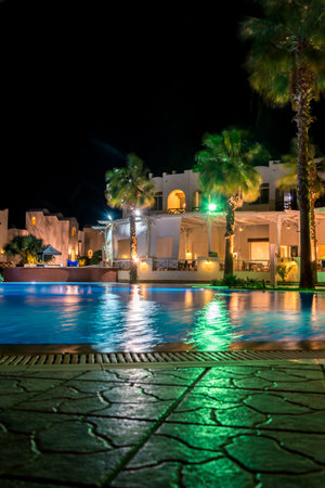Sharm el-Sheikh, Egypt, 02/25/2019. Night landscape, interior of the hotel overlooking the pool, houses and palm trees. Vertical frameのeditorial素材