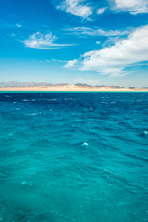 Seascape, view of the blue sea with high bald mountains in the background. Vertical frameの写真素材
