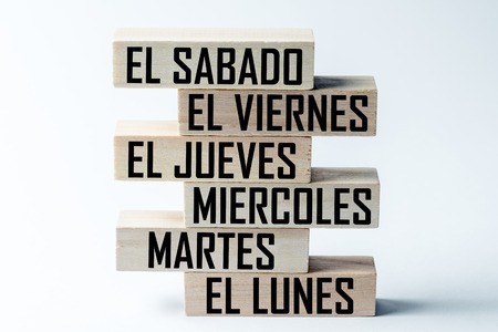 A list of wooden blocks lying on top of each other with a list of six-day working week days in Spanish, in the translation of the word: saturday, friday, thursday, wednesday, tuesday, mondayの写真素材