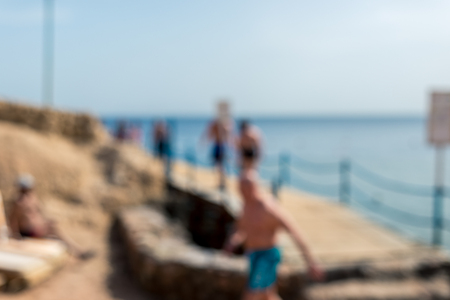 Blur using the defocus, people relax on the beach. Horizontal frameの写真素材