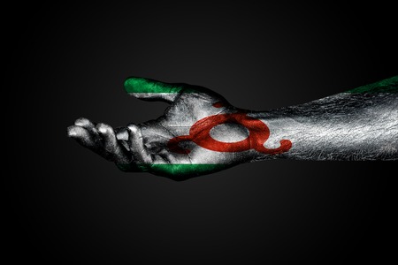 Outstretched hand with a drawn Ingushetia flag, a sign of help or a request, on a dark background. Horizontal frameの写真素材