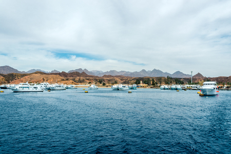 seascape, blue sea with mountains in the background and several yachts in the distance. Horizontal frameの写真素材