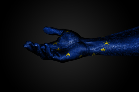 Outstretched hand with a drawn EU flag, a sign of help or a request, on a dark background. Horizontal frameの写真素材