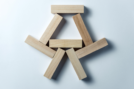 abstract geometric figure from wooden cubes, on an uneven white background