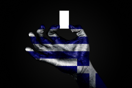 hand with a painted flag Greece holding a small white sheet with space for an inscription, mock up. Horizontal frameの写真素材