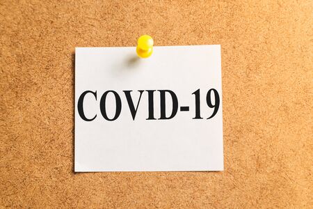 White sticker for notes with the inscription "COVID-19".の写真素材