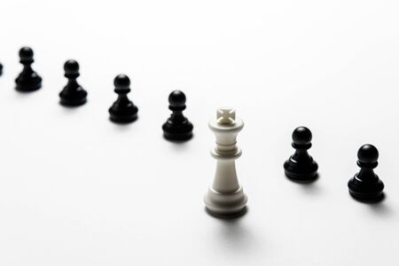 chess white king stands against black pawns. Symbol of leadership and confrontation.の写真素材