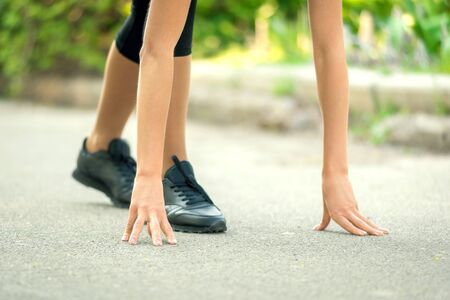 girl with dark hair in sportswear getting ready for a run.の写真素材