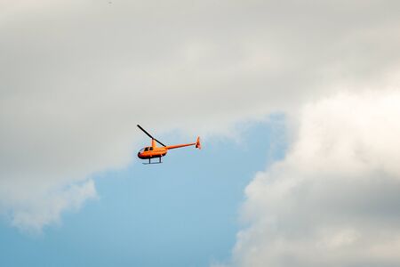 yellow helicopter high in the sky.の写真素材