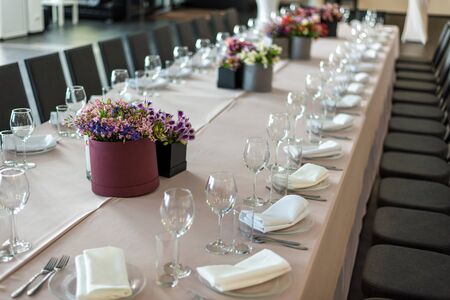 a long table served with dishes and flowers.