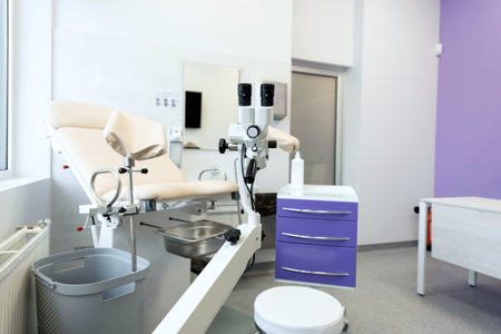 a modern microscope connected to a reflex camera against the background of a medical chairの写真素材