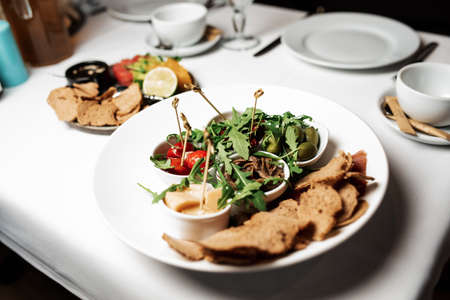 assorted cheese, olives, tomato and croutons on a plateの写真素材