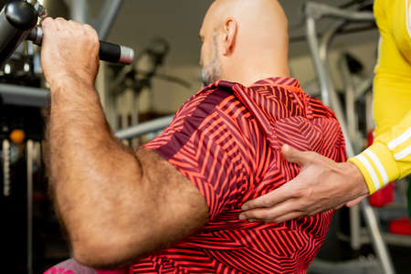 close-up hand of a gym trainer helping an athleteの写真素材