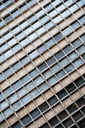 Glass gray square Windows of modern city business building skyscraper. Glass balconies in the...