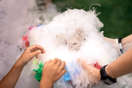 delicious ice cream in cups in smoke with child's handsの写真素材