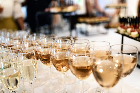 many glasses of white wine stand in a row on the tableの写真素材
