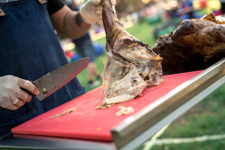 the hands of the cook cut the greased carcass of the rabbitの写真素材