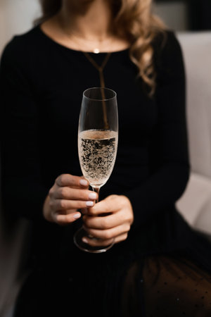 Glass of white sparkling champagne in woman's handsの写真素材