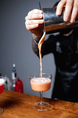 Mixed cocktails, party smoothies and frozen summer drinks concept with strawberry mojito or daiquiri in margarita glasses, strawberries and limes on bar counterの写真素材