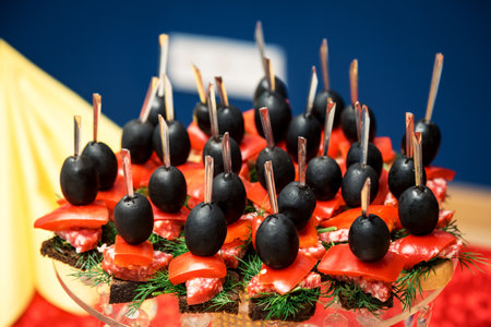 Christmas canape on skewer from bread baguette with toast cheese, sausage, tomato, cucumber and olives. Traditional snack for the New Year or Christmas party.の写真素材