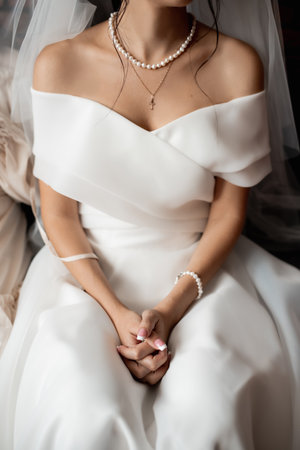 young girl in a white wedding dress keeps her hands claspedの写真素材