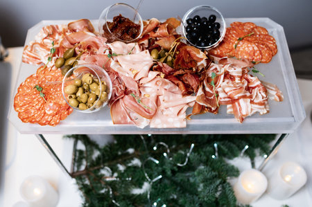 plate with meat, salami, ham, backon, prosciutto on Dark gray black slate background