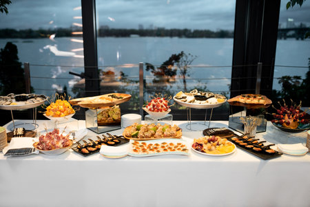 Buffet table of reception with burgers, cold snacks, oysters, meat and saladsの写真素材