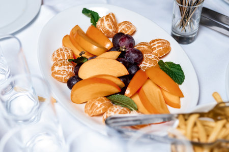 Tropical fruits assortment. tiered fruit platter.pear, pineapple, tangerine, grapes, persimmon, passion fruitの写真素材