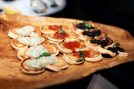 a lot of pancakes with red, black and white caviarの写真素材