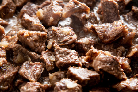 close-up beautiful large pieces of fried meat with onions in a panの写真素材