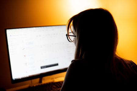 Back behind view photo of dark skin programmer lady look big monitor check id-address work overtime check debugging system wear specs casual shirt sit table late night office indoorsの写真素材