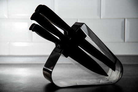 kitchen knives in a wooden stand on a white backgroundの写真素材